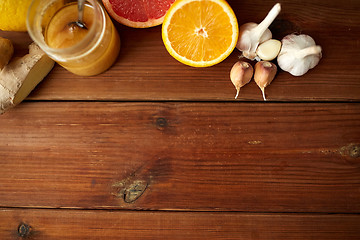 Image showing honey, citrus fruits, ginger and garlic on wood