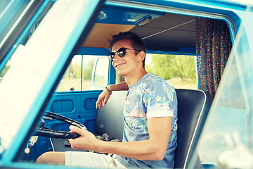 Image showing smiling young hippie man driving minivan car