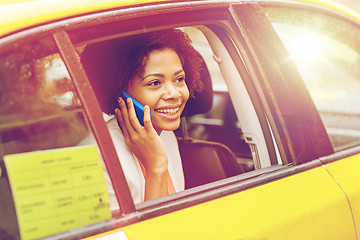 Image showing happy african woman calling on smartphone in taxi