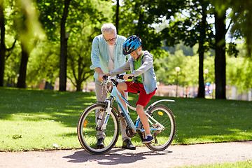 Image showing grandfather and boy with bicycle at summer park