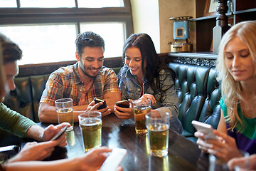 Image showing friends with smartphones and beer at bar or pub