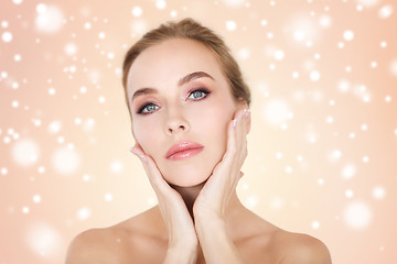 Image showing beautiful young woman face and hands over snow