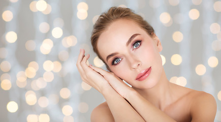 Image showing beautiful woman face and hands over lights