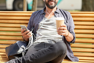 Image showing man with earphones and smartphone drinking coffee