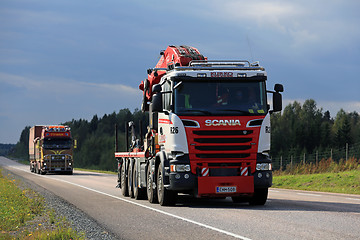 Image showing Two Trucks Trucking Under Dark Sky