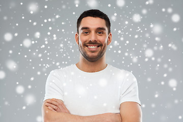 Image showing smiling man with crossed arms over snow background