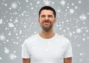 Image showing man screwing up his face over snow background