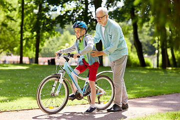 Image showing grandfather and boy with bicycle at summer park