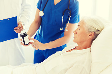 Image showing doctor giving medicine to senior woman at hospital