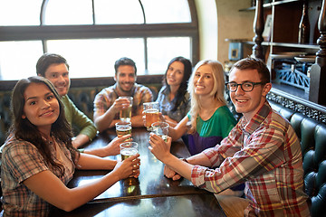 Image showing happy friends drinking beer at bar or pub