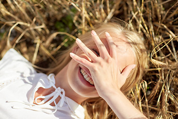 Image showing happy young woman lying on cereal field