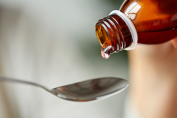 Image showing medication or antipyretic syrup and spoon