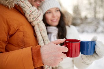 Image showing close up of happy couple with tea cups in winter