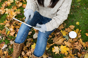 Image showing woman with tablet pc and coffee in autumn park