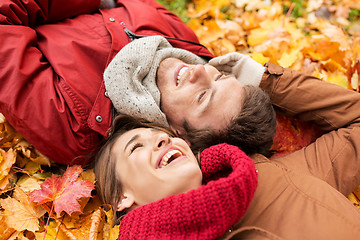 Image showing close up of smiling couple lying on autumn leaves