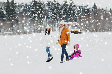 Image showing happy family with sled walking in winter forest