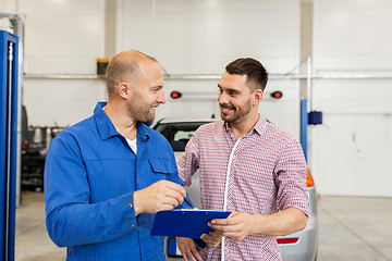 Image showing auto mechanic with clipboard and man at car shop