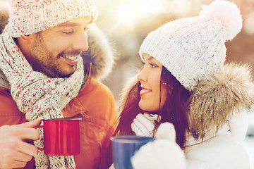 Image showing happy couple with tea cups over winter landscape