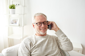 Image showing happy senior man calling on smartphone at home