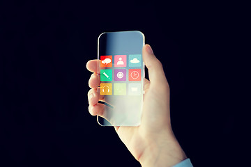 Image showing close up of male hand with transparent smartphone