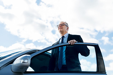 Image showing senior businessman getting into car