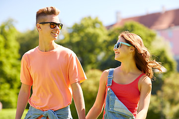 Image showing happy teenage couple walking at summer park