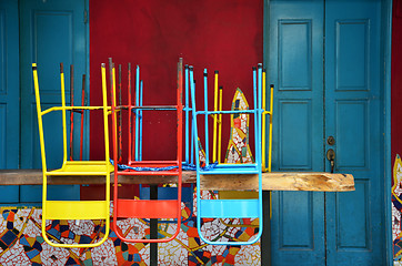 Image showing Colorful chairs on a wooden table
