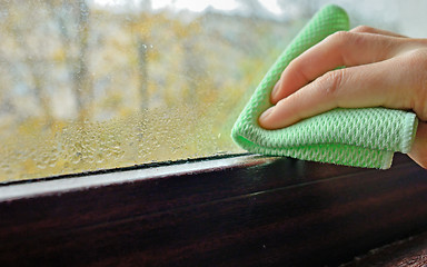 Image showing Cleaning water  condensation on window