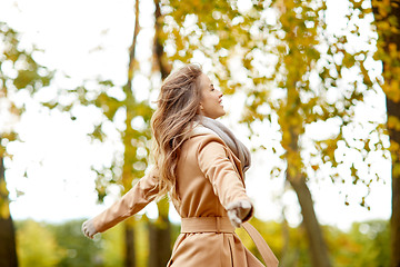 Image showing beautiful happy young woman walking in autumn park