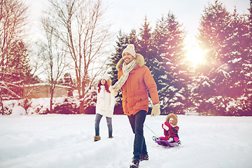 Image showing happy family with sled walking in winter outdoors