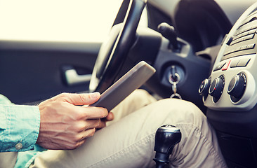 Image showing close up of young man with tablet pc driving car