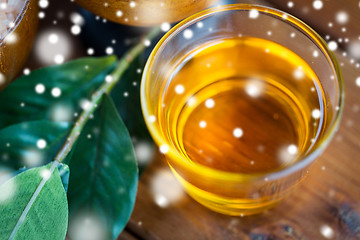 Image showing close up of honey in glass with leaves on wood