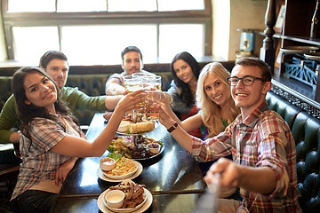 Image showing happy friends with selfie stick at bar or pub