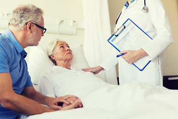 Image showing senior woman and doctor with clipboard at hospital