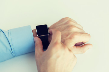 Image showing close up of male hands setting smart watch