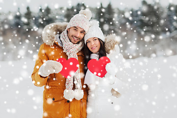 Image showing happy couple with red hearts over winter landscape