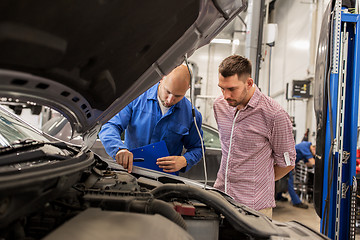 Image showing auto mechanic with clipboard and man at car shop