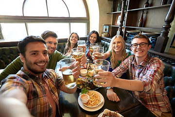 Image showing happy friends taking selfie at bar or pub