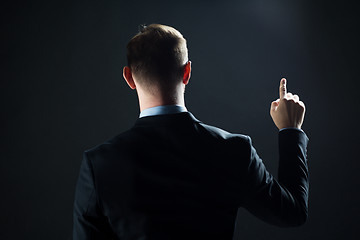 Image showing businessman pointing finger to something invisible