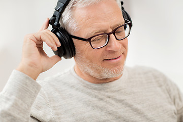 Image showing happy man in headphones listening to music at home