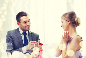 Image showing man proposing to his girlfriend at restaurant