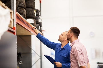 Image showing auto mechanic with clipboard and man at car shop