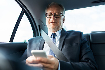 Image showing senior businessman texting on smartphone in car