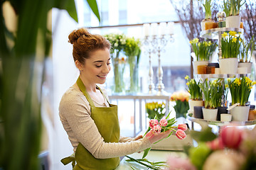 Image showing smiling florist woman making bunch at flower shop