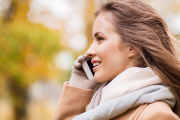 Image showing woman calling on smartphone in autumn park