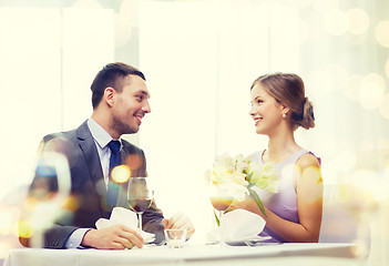 Image showing smiling man giving flower bouquet at restaurant