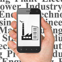 Image showing Industry concept: Hand Holding Smartphone with Industry Building on display