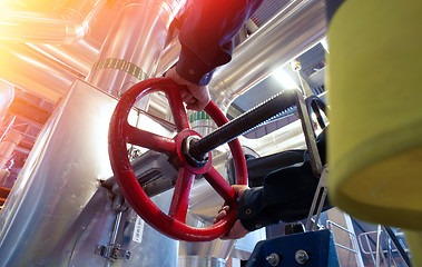 Image showing factory worker turning valve