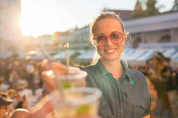 Image showing Beautiful young girl toasting on outdoor urban event.