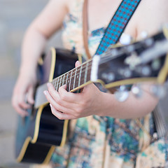 Image showing Female street musician playing guitar.